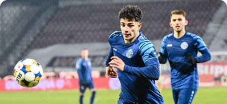 Jucător Metaloglobus și Csíkszereda în acțiune, fundal stadion cu public